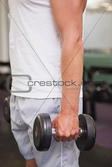 Fit man lifting heavy black dumbbell