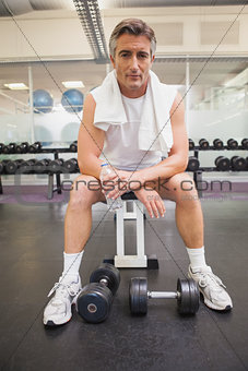 Fit man taking a break in the weights room
