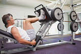 Fit man using weights machine for legs