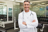 Confident doctor standing in weights room