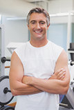 Fit man smiling at camera in fitness studio