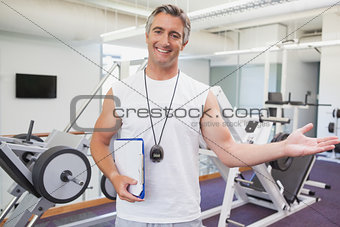 Fit personal trainer smiling at camera in fitness studio