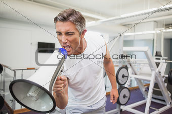 Angry personal trainer shouting through megaphone