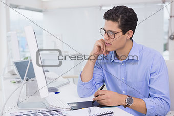 Casual graphic designer working at his desk