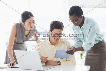 Casual business team looking at tablet together
