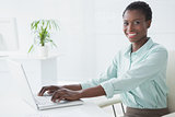 Happy businesswoman using her laptop