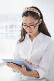 Businesswoman sitting and using tablet