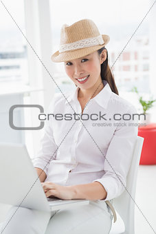 Hipster businesswoman sitting and using laptop