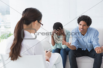 Angry couple talking to their therapist