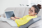 Young creative woman using laptop on couch
