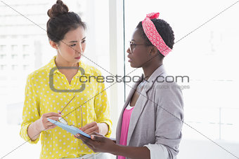 Young creative women looking at tablet