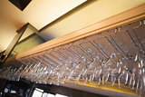 Many wine glasses hanging above the bar