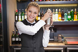 Pretty blonde waitress shaking cocktail