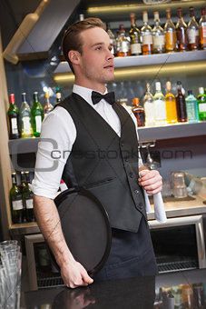 Serious waiter holding tray and towel