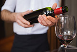 Waiter pouring a bottle of red wine
