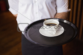 Waiter holding tray with coffee cup