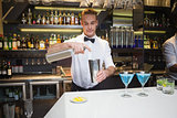 Smiling bartender preparing a drink at bar counter
