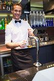Handsome barkeeper pulling a pint of beer
