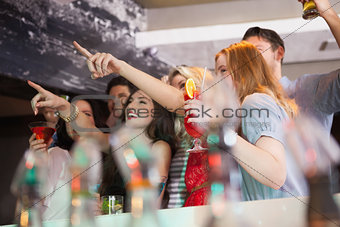Friends having a drink together and pointing something