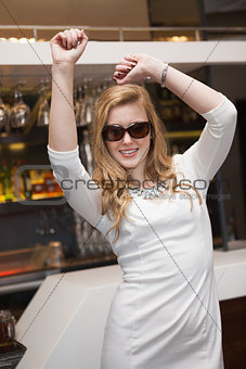 Pretty brunette dancing and smiling with sunglasses