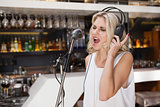 Woman with headphone singing while closing her eyes