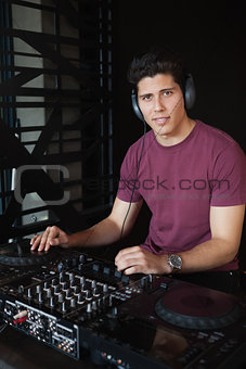 Cool dj working on a sound mixing desk