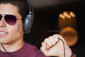 Man in sunglasses listening to music with headphone