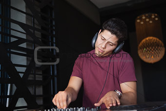 Cool dj working on a sound mixing desk