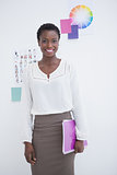 Smiling businesswoman standing and holding notebook