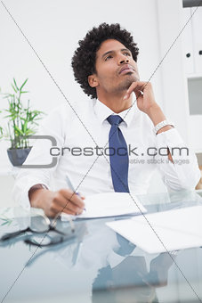 Businessman in shirt writing and thinking