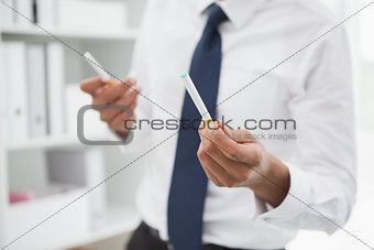 Mid section of a businessman holding cigarettes