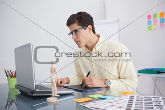 Focused designer using digitizer at his desk