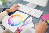 Designer using computer and colour wheel