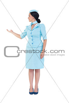 Pretty air hostess showing with hand