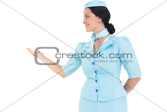 Pretty air hostess presenting with hand