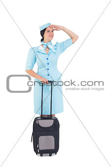 Pretty air hostess holding suitcase