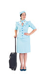 Pretty air hostess holding suitcase