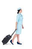Pretty air hostess walking with suitcase