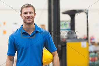 Handsome warehouse worker smiling at camera