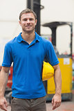 Handsome warehouse worker smiling at camera