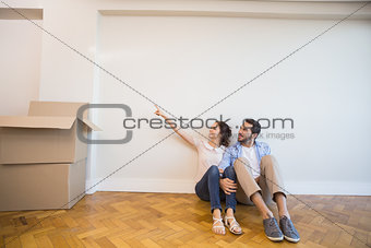 Cute couple pointing to the wall