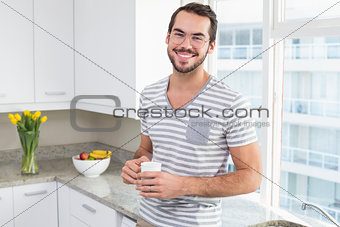 Young man smiling and holding coffee