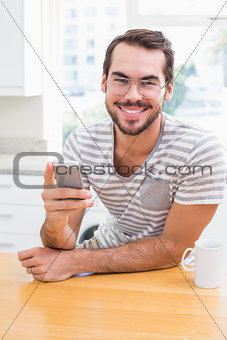 Young man using smartphone while having coffee