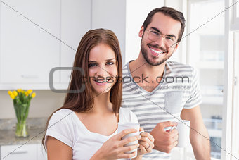 Young couple smiling at the camera having coffee