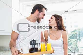 Young couple with breakfast on tray