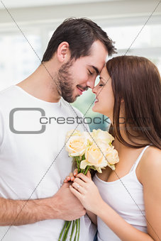 Young man giving girlfriend white roses