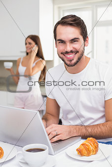 Young man using laptop at breakfast