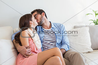 Young couple kissing on couch