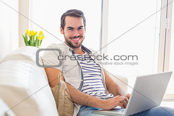 Hipster man using laptop on couch