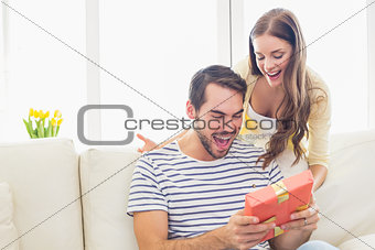 Pretty woman surprising her boyfriend with gift